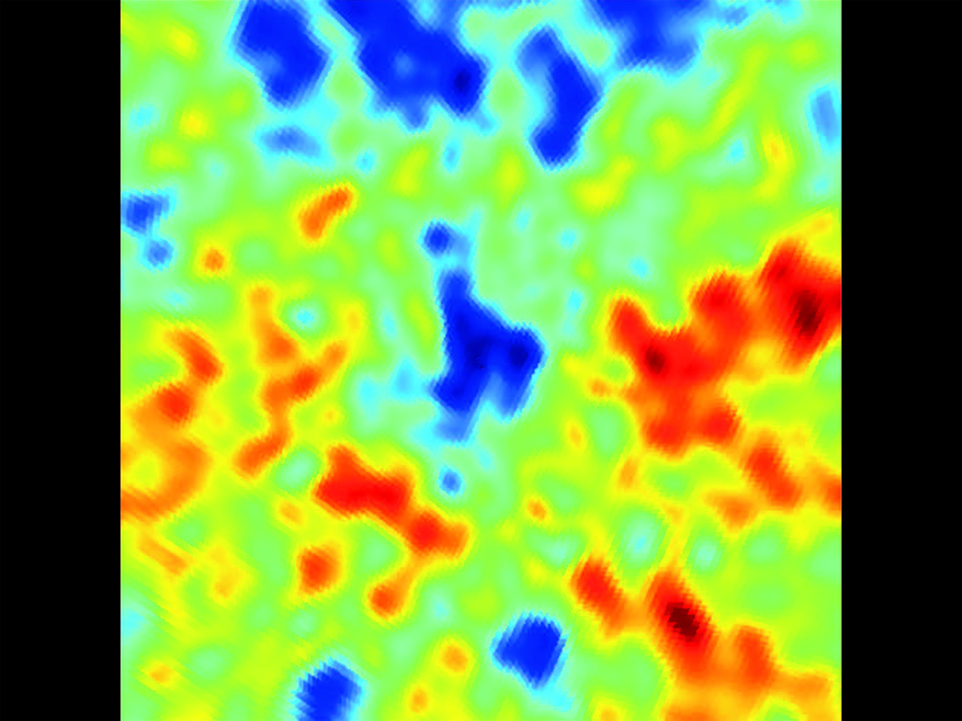 A thermal diagram from the background radiation of microwaves in the cosmos, showing a bluish blotch of coldness amid much warmer regions, represented by zones of green, amber, and rouge.